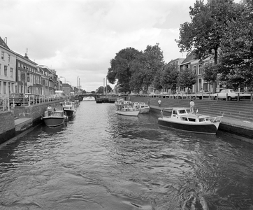 855985 Gezicht over de Weerdsluis te Utrecht, met aangemeerde pleziervaartuigen, vanaf de loopbrug over de sluis naar ...
